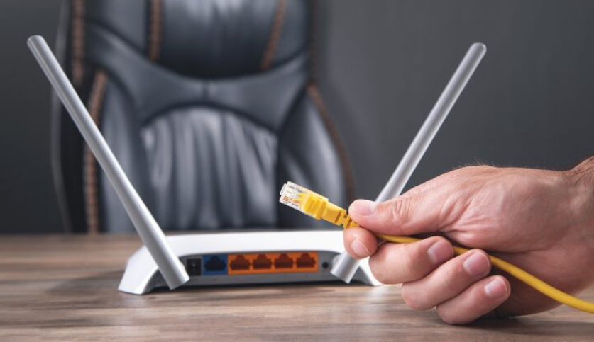 Ethernet cable being connected to a Wi-Fi router to improve network speed and stability